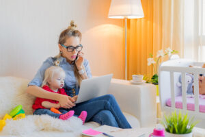 Mom with toddler working on laptop